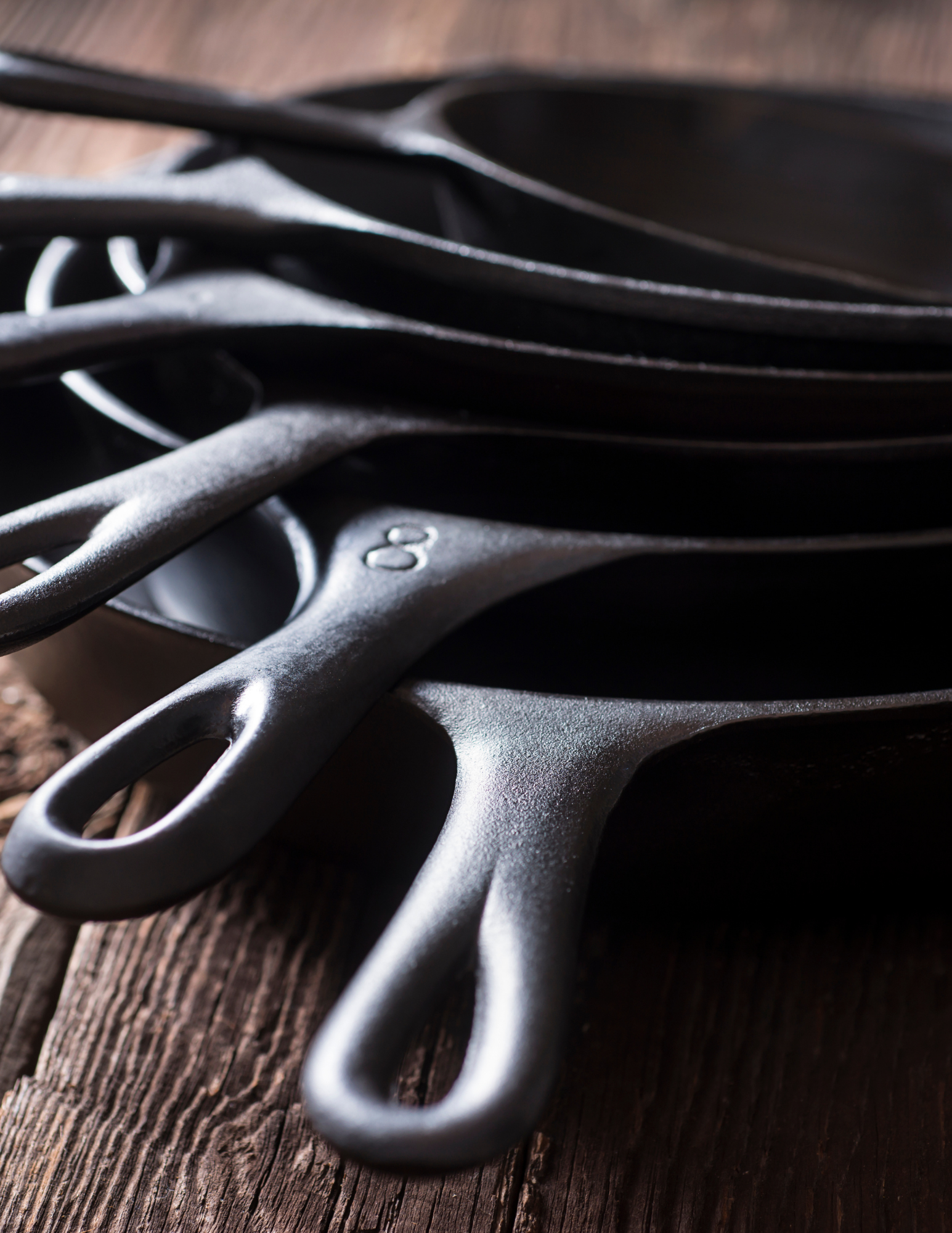 Seasoned cast iron skillets stacked and ready — the Working Kitchen in Idaho
